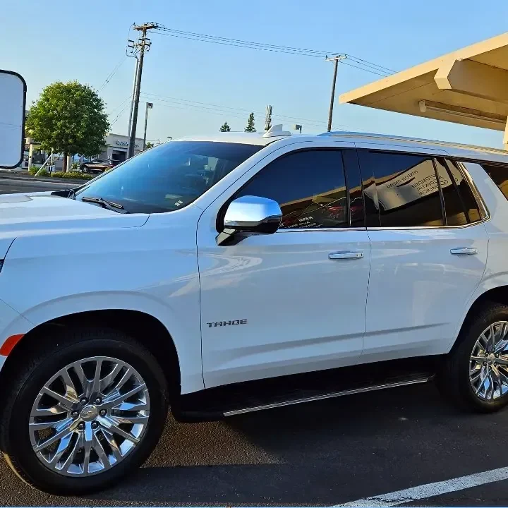 White 2023 Chevrolet Tahoe with freshly tinted windows, in the King Auto Tint parking lot on Fulton Avenue, Sacramento