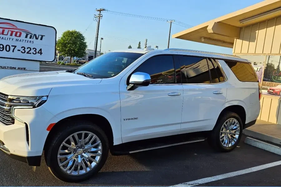 White 2023 Chevrolet Tahoe with freshly tinted windows, in the King Auto Tint parking lot on Fulton Avenue, Sacramento
