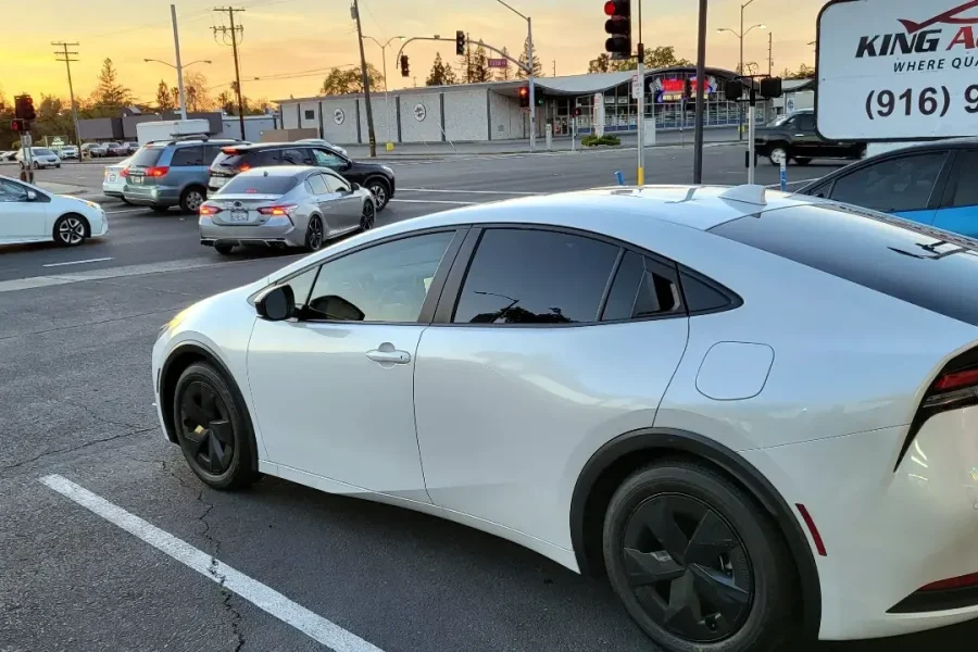 White 2023 Toyota Prius with freshly tinted windows, photographed after its tint job at King Auto Tint in Sacramento