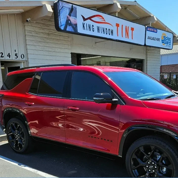 Red 2024 Chevrolet Traverse with freshly tinted windows, parked in front of King Window Tint at 2450 Fulton Ave, Sacramento