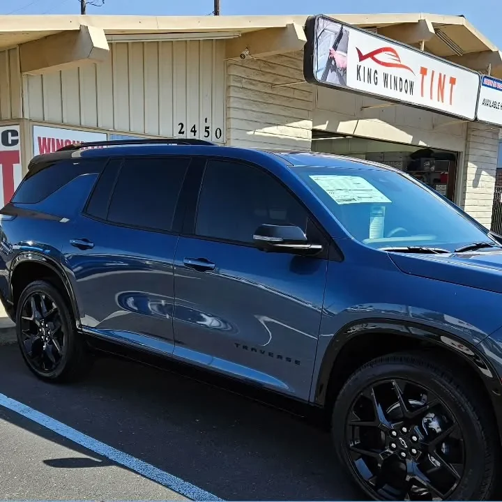 Blue 2024 Chevrolet Traverse with freshly tinted windows, outside the King Window Tint shop on Fulton Ave in Sacramento