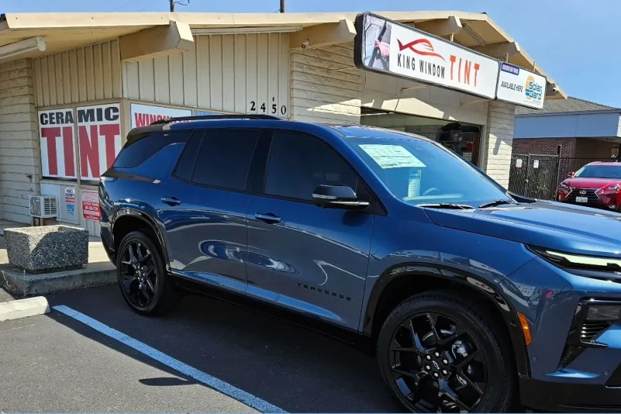 Blue 2024 Chevrolet Traverse with freshly tinted windows, outside the King Window Tint shop on Fulton Ave in Sacramento