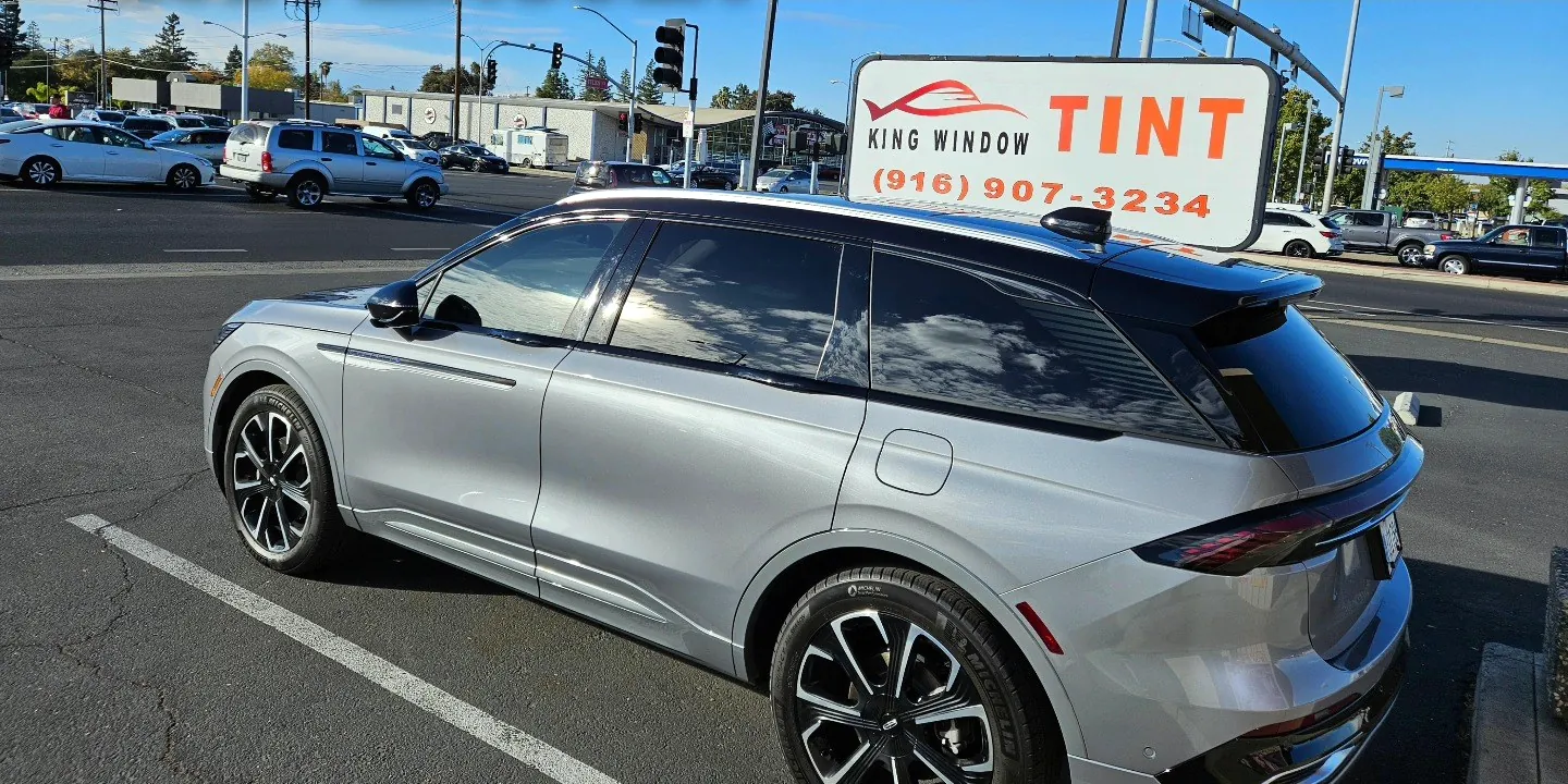 Side profile of an SUV showing light front window tint and darker rear window tint outside King Auto Tint