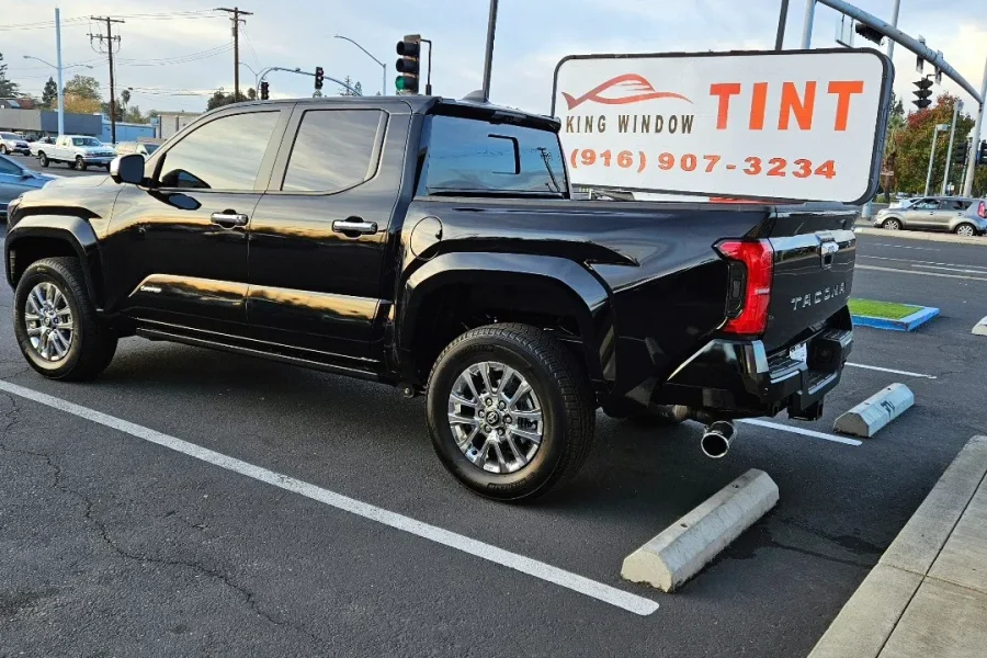 Black 2024 Toyota Tacoma with freshly tinted windows, in the King Window Tint parking lot on Fulton Avenue, Sacramento