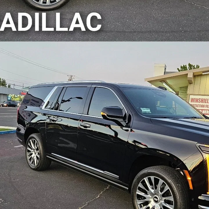 Black 2025 Cadillac Escalade ESV with freshly tinted windows, beside the King Window Tint sign on Fulton Ave, Sacramento