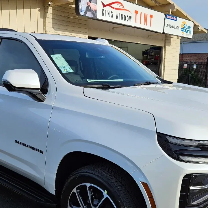 White 2025 Chevrolet Suburban with freshly tinted windows, in the King Window Tint parking lot on Fulton Avenue, Sacramento