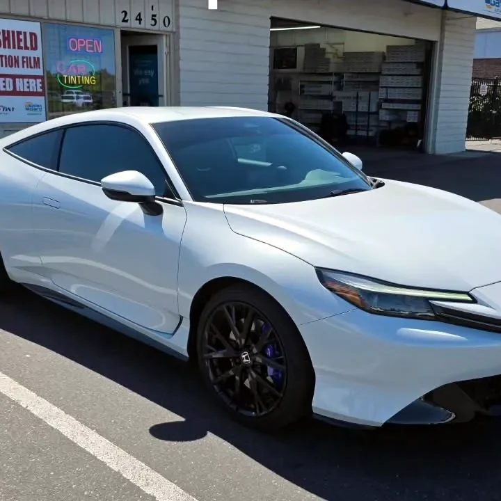 White 2026 Honda Prelude with freshly tinted windows, beside the King Window Tint sign on Fulton Ave, Sacramento