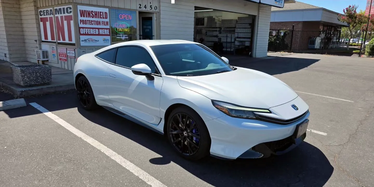 White 2026 Honda Prelude with freshly tinted windows, beside the King Window Tint sign on Fulton Ave, Sacramento