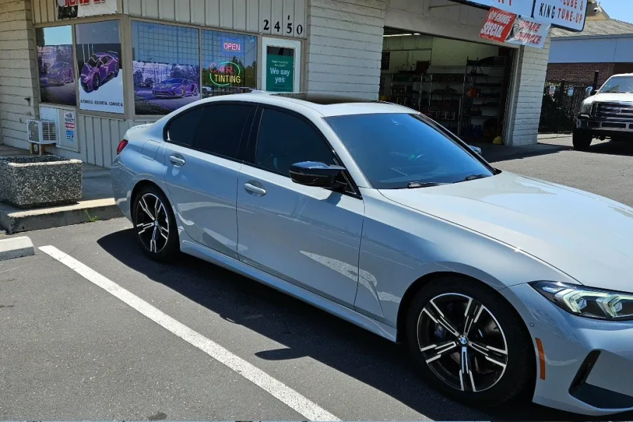 Silver BMW 3 Series with freshly tinted windows, in the King Window Tint parking lot on Fulton Avenue, Sacramento