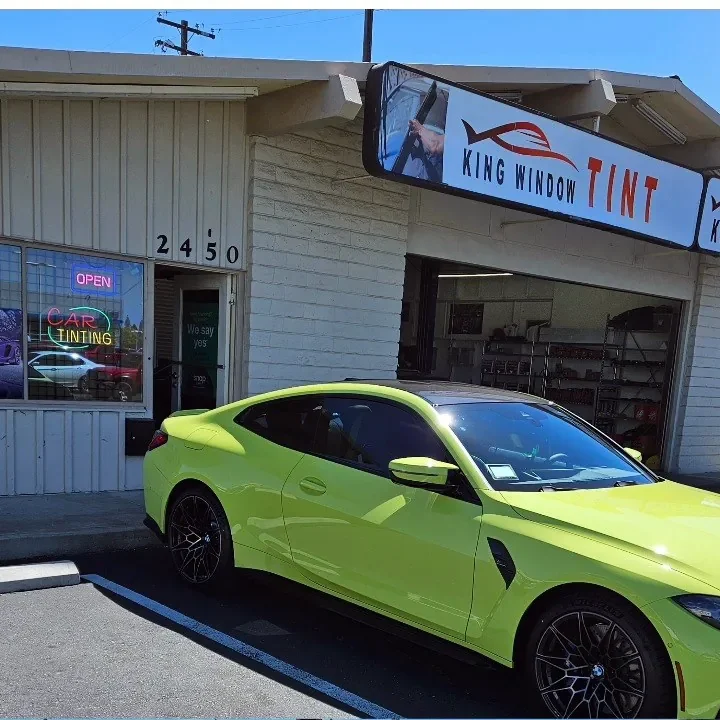 Lime yellow BMW M4 with freshly tinted windows, parked in front of King Window Tint at 2450 Fulton Ave, Sacramento