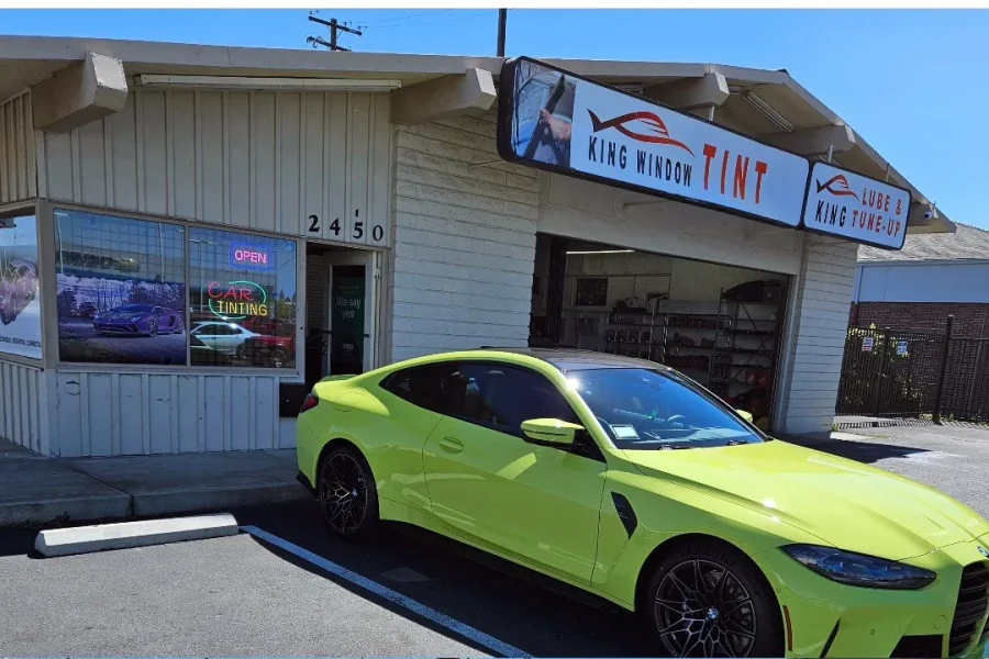 Lime yellow BMW M4 with freshly tinted windows, parked in front of King Window Tint at 2450 Fulton Ave, Sacramento