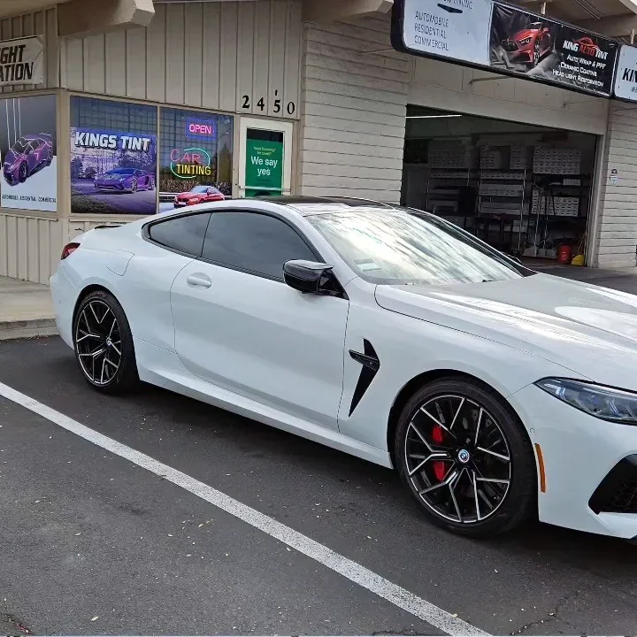 White BMW M8 with freshly tinted windows, parked in front of King Auto Tint at 2450 Fulton Ave, Sacramento