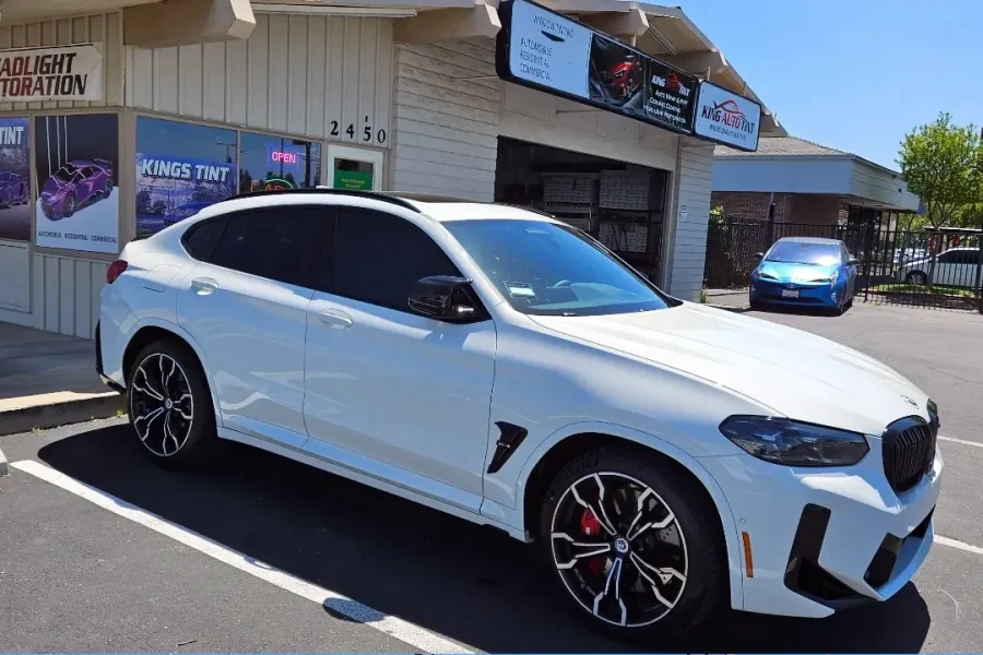 White BMW X4 with freshly tinted windows, parked in front of King Auto Tint at 2450 Fulton Ave, Sacramento