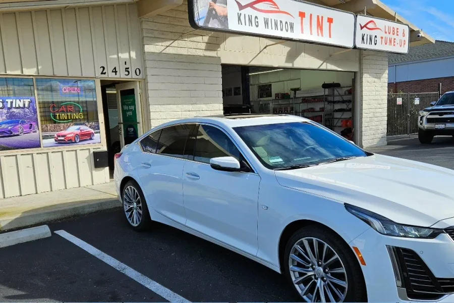 White Cadillac CT5 with freshly tinted windows, in the King Window Tint parking lot on Fulton Avenue, Sacramento