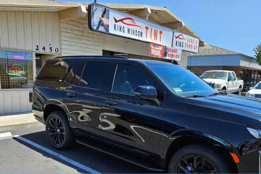Black Cadillac Escalade with freshly tinted windows, in the King Window Tint parking lot on Fulton Avenue, Sacramento, view 2