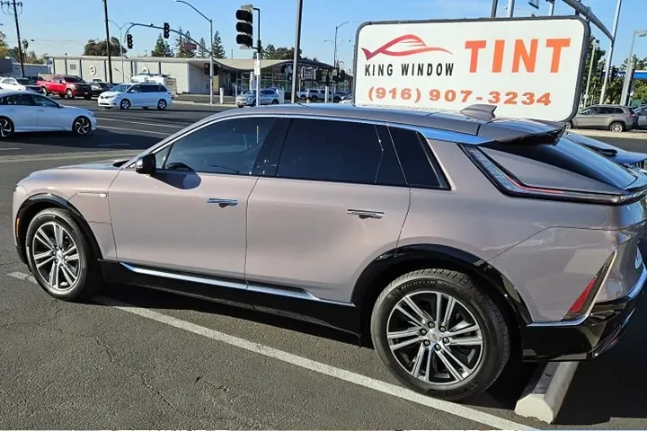 Rose gray Cadillac Lyriq with freshly tinted windows, outside the King Window Tint shop on Fulton Ave in Sacramento