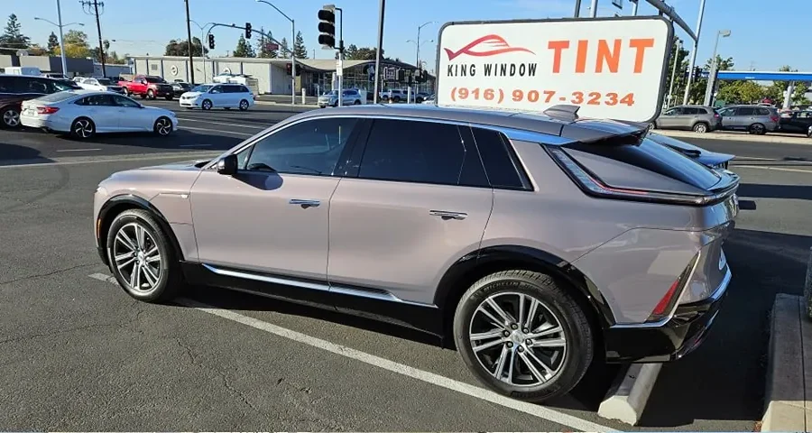 Rose gray Cadillac Lyriq with freshly tinted windows, outside the King Window Tint shop on Fulton Ave in Sacramento