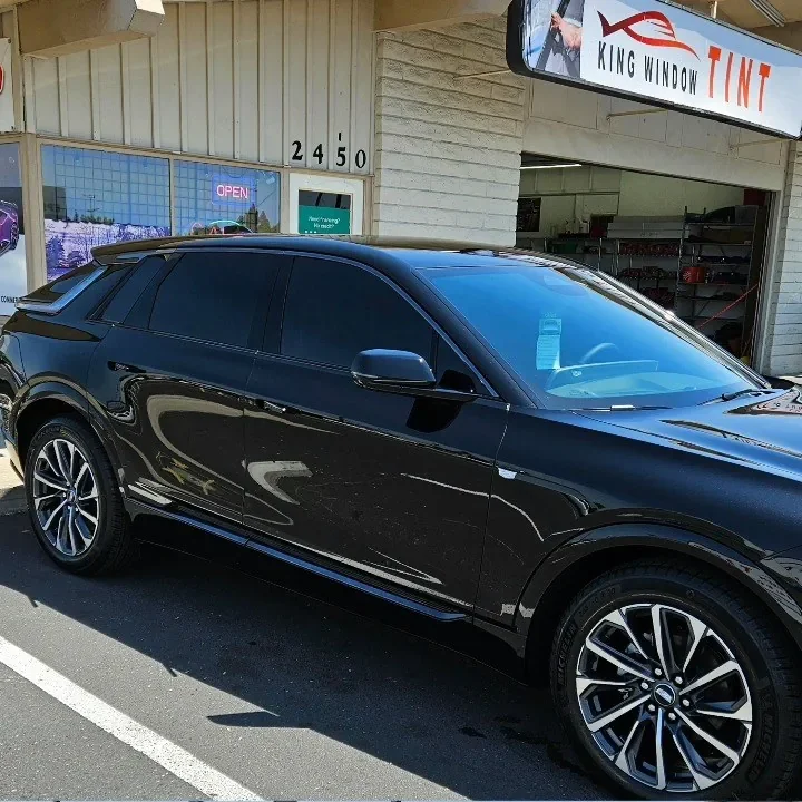 Black Cadillac Optiq with freshly tinted windows, in the King Window Tint parking lot on Fulton Avenue, Sacramento