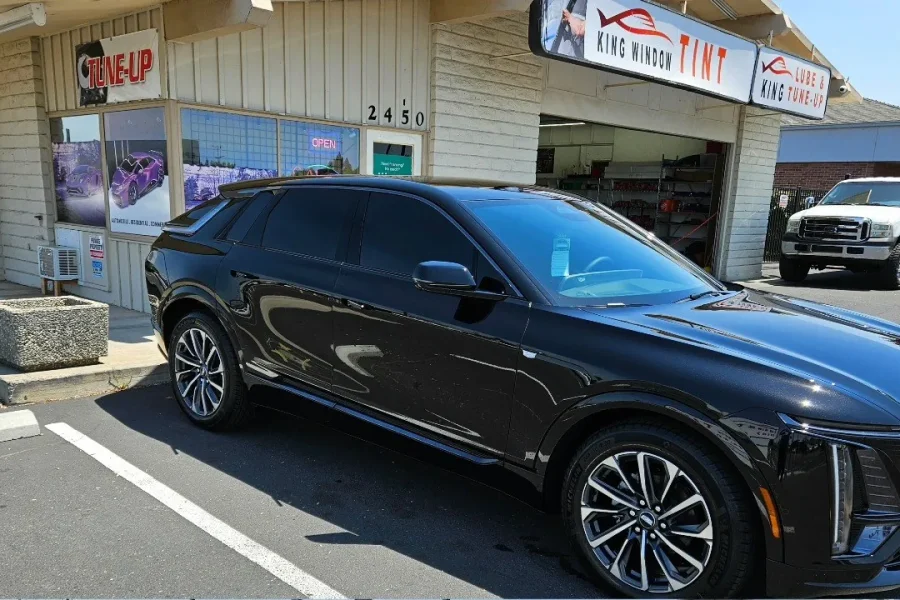 Black Cadillac Optiq with freshly tinted windows, in the King Window Tint parking lot on Fulton Avenue, Sacramento