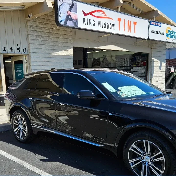 Black Cadillac Optiq with freshly tinted windows, outside the King Window Tint shop on Fulton Ave in Sacramento