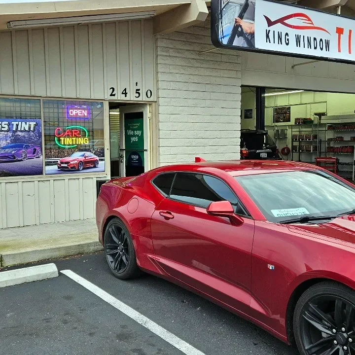 Red Chevrolet Camaro with freshly tinted windows, parked in front of King Window Tint at 2450 Fulton Ave, Sacramento