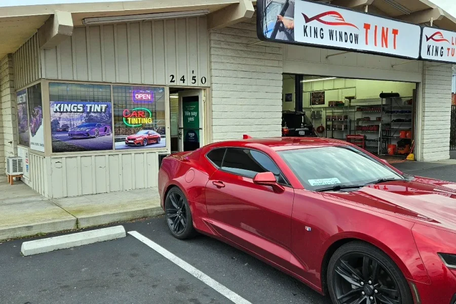 Red Chevrolet Camaro with freshly tinted windows, parked in front of King Window Tint at 2450 Fulton Ave, Sacramento