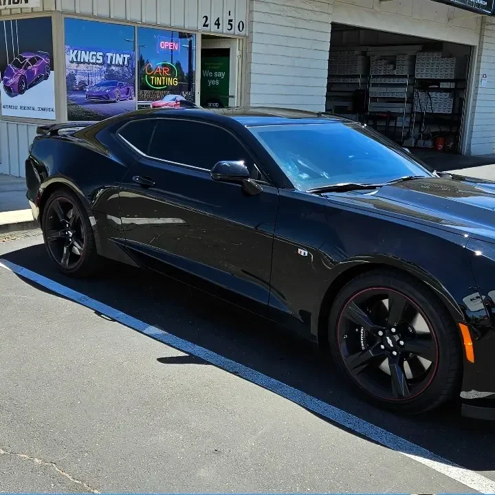 Black Chevrolet Camaro with freshly tinted windows, parked in front of King Auto Tint at 2450 Fulton Ave, Sacramento