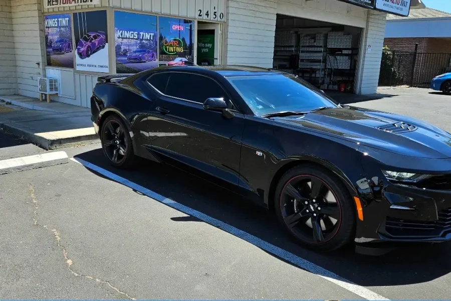 Black Chevrolet Camaro with freshly tinted windows, parked in front of King Auto Tint at 2450 Fulton Ave, Sacramento