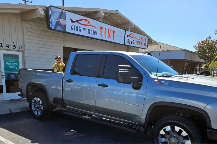 Silver Chevrolet Silverado 2500HD with freshly tinted windows, parked in front of King Window Tint at 2450 Fulton Ave, Sacramento