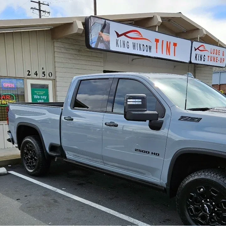 Gray Chevrolet Silverado 2500HD with freshly tinted windows, outside the King Window Tint shop on Fulton Ave in Sacramento