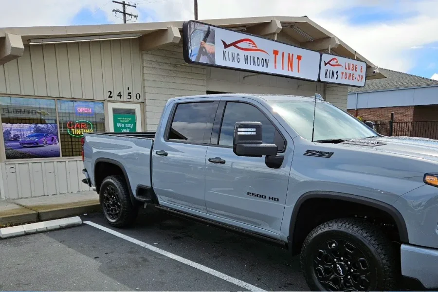 Gray Chevrolet Silverado 2500HD with freshly tinted windows, outside the King Window Tint shop on Fulton Ave in Sacramento