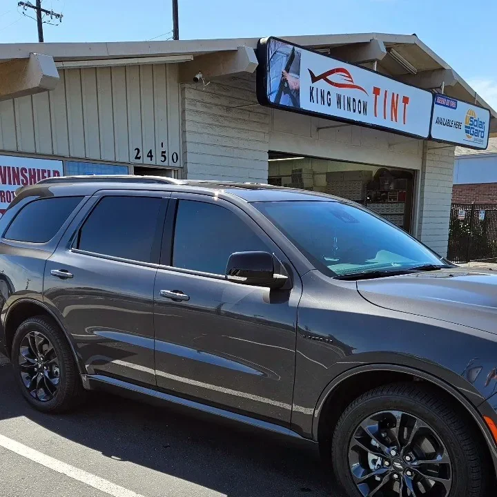 Gray Dodge Durango with freshly tinted windows, parked in front of King Window Tint at 2450 Fulton Ave, Sacramento
