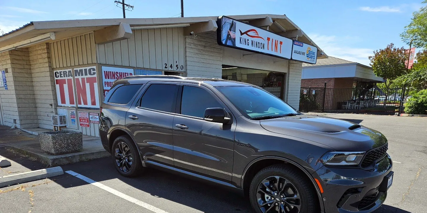 Gray Dodge Durango with freshly tinted windows, parked in front of King Window Tint at 2450 Fulton Ave, Sacramento