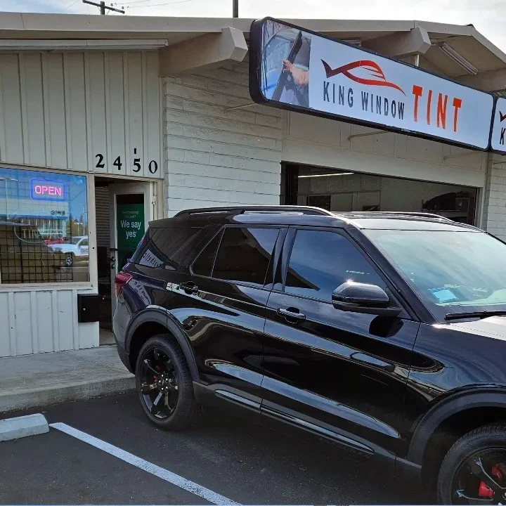Black Ford Explorer ST with freshly tinted windows, beside the King Window Tint sign on Fulton Ave, Sacramento