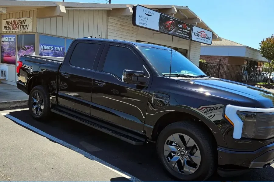 Black Ford F-150 Lightning with freshly tinted windows, outside the King Auto Tint shop on Fulton Ave in Sacramento