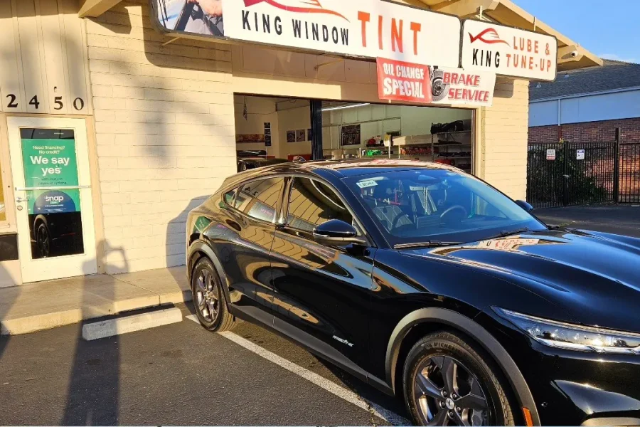 Black Ford Mustang Mach-E with freshly tinted windows, in the King Window Tint parking lot on Fulton Avenue, Sacramento