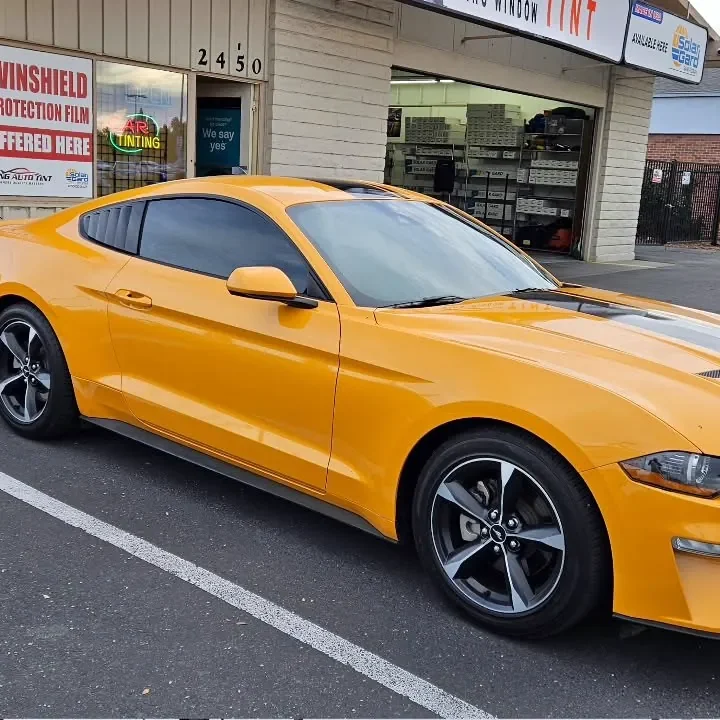 Orange Ford Mustang with freshly tinted windows, outside the King Window Tint shop on Fulton Ave in Sacramento