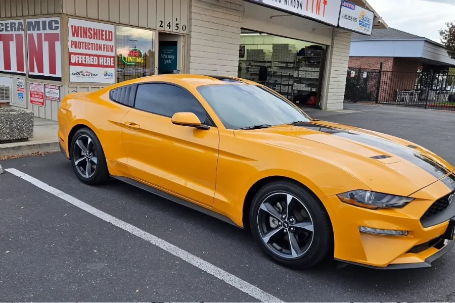 Orange Ford Mustang with freshly tinted windows, outside the King Window Tint shop on Fulton Ave in Sacramento