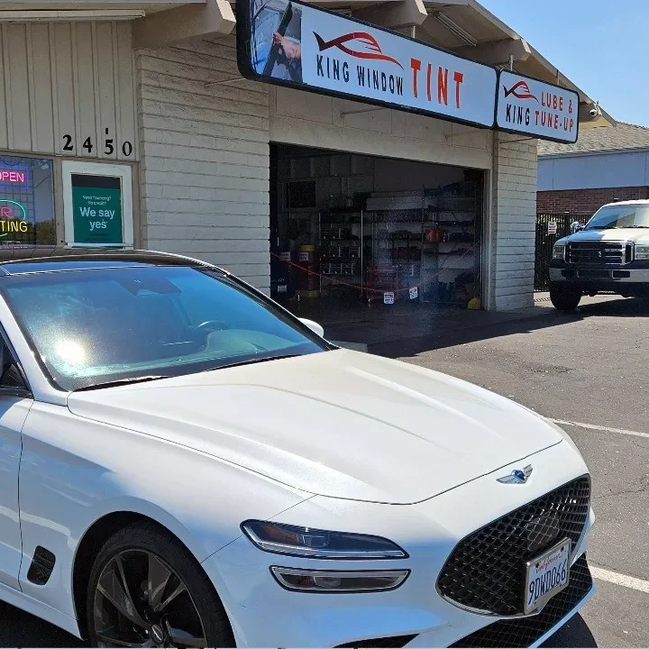 White Genesis G70 with freshly tinted windows, outside the King Window Tint shop on Fulton Ave in Sacramento