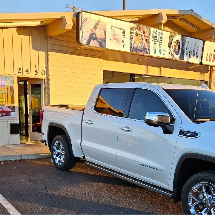 White GMC Sierra 1500 Denali with freshly tinted windows, in the King Auto Tint parking lot on Fulton Avenue, Sacramento