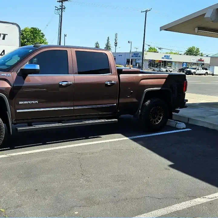 Brown GMC Sierra 1500 with freshly tinted windows, outside the King Auto Tint shop on Fulton Ave in Sacramento