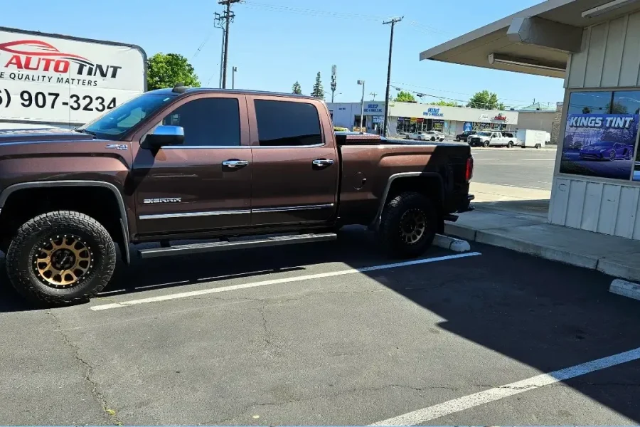 Brown GMC Sierra 1500 with freshly tinted windows, outside the King Auto Tint shop on Fulton Ave in Sacramento