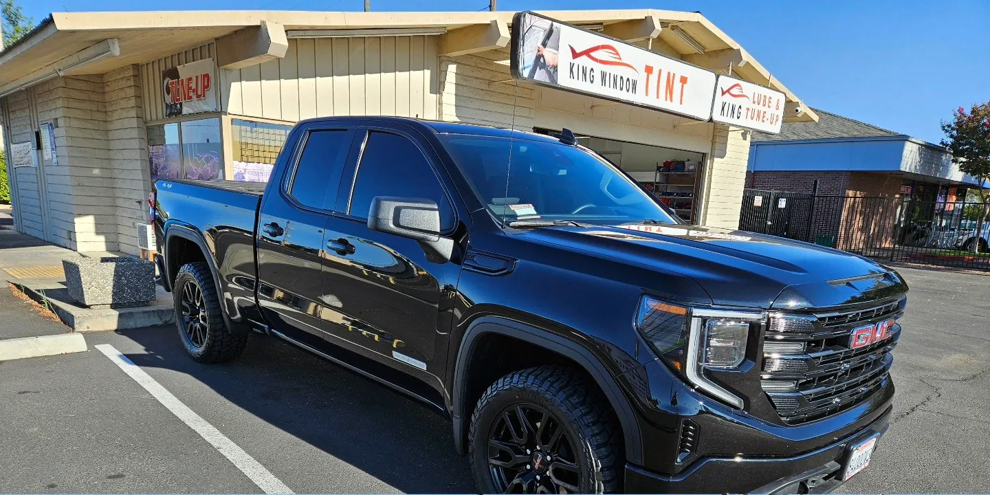 Black GMC Sierra 1500 with freshly tinted windows, outside the King Window Tint shop on Fulton Ave in Sacramento