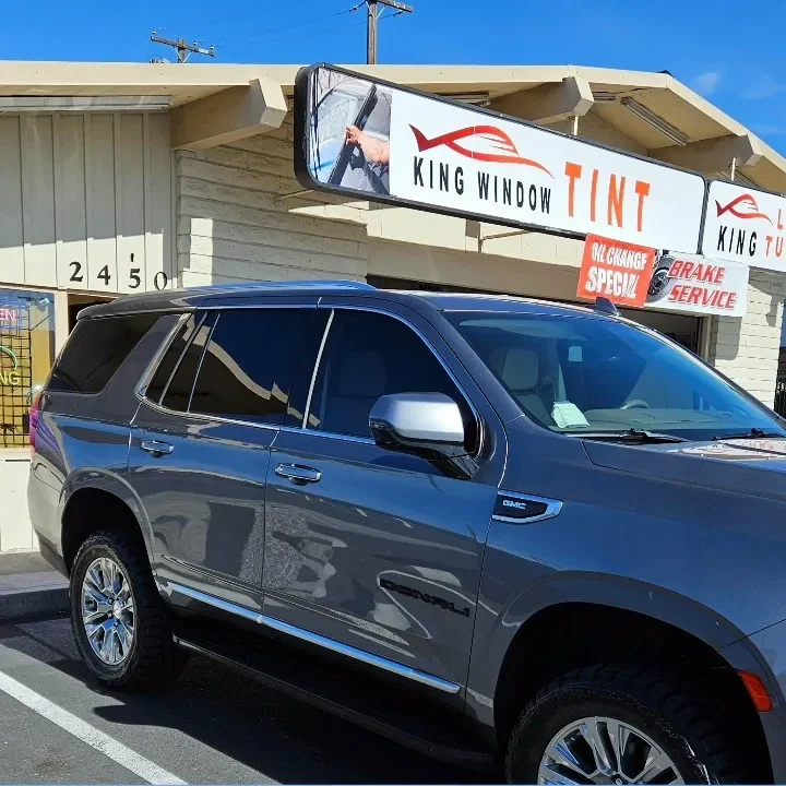 Gray GMC Yukon Denali with freshly tinted windows, parked in front of King Window Tint at 2450 Fulton Ave, Sacramento