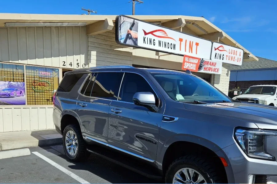 Gray GMC Yukon Denali with freshly tinted windows, parked in front of King Window Tint at 2450 Fulton Ave, Sacramento