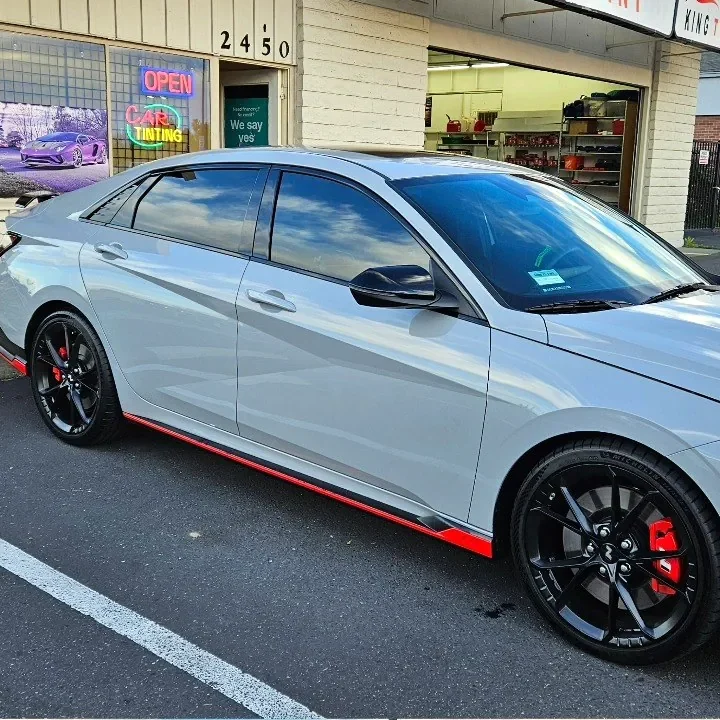 Gray Hyundai Elantra N with freshly tinted windows, beside the King Window Tint sign on Fulton Ave, Sacramento