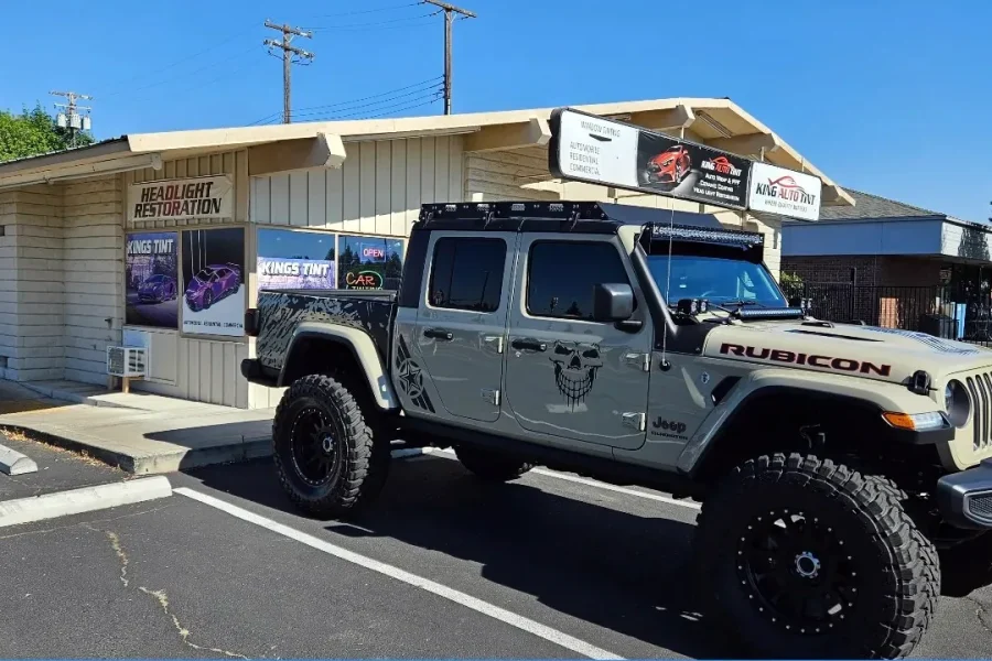 Tan Jeep Gladiator Rubicon with freshly tinted windows, in the King Auto Tint parking lot on Fulton Avenue, Sacramento (lifted)