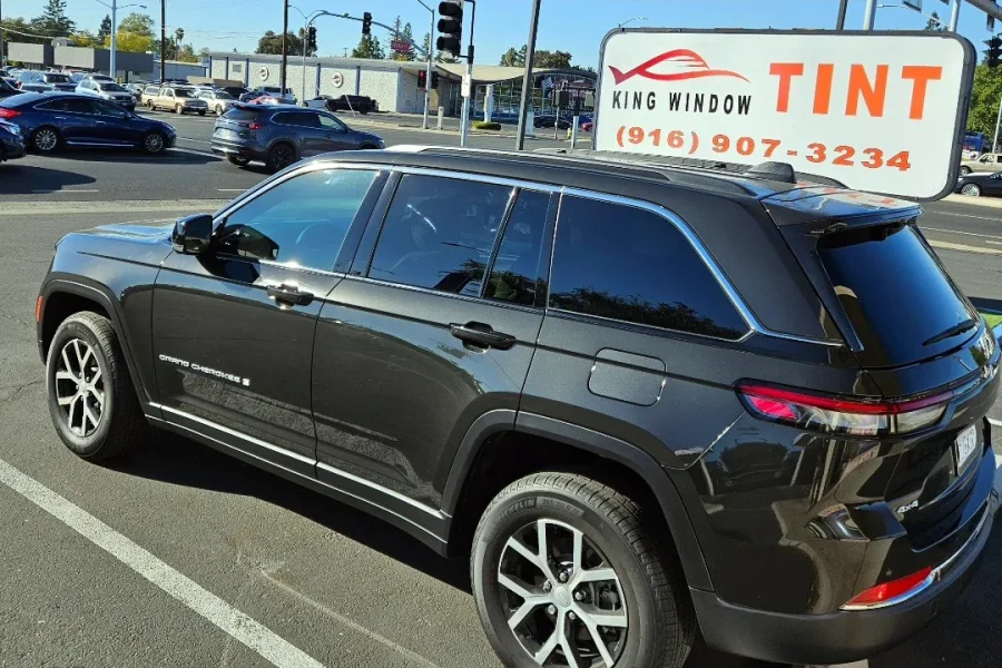 Black Jeep Grand Cherokee with freshly tinted windows, parked in front of King Window Tint at 2450 Fulton Ave, Sacramento