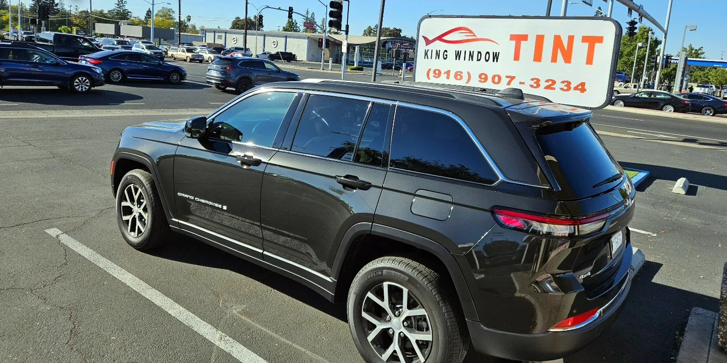 Black Jeep Grand Cherokee with freshly tinted windows, parked in front of King Window Tint at 2450 Fulton Ave, Sacramento