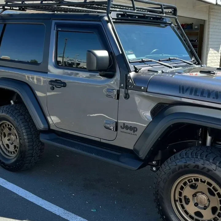 Gray Jeep Wrangler Willys with freshly tinted windows, beside the King Window Tint sign on Fulton Ave, Sacramento (two-door)